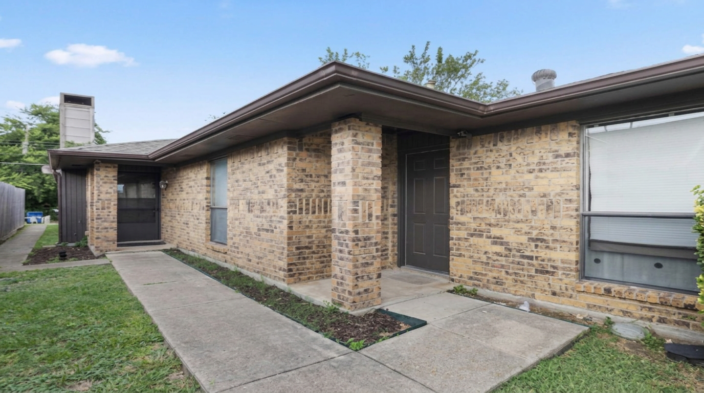 Well-kept brick home with a tidy walkway and green lawn on a bright day.