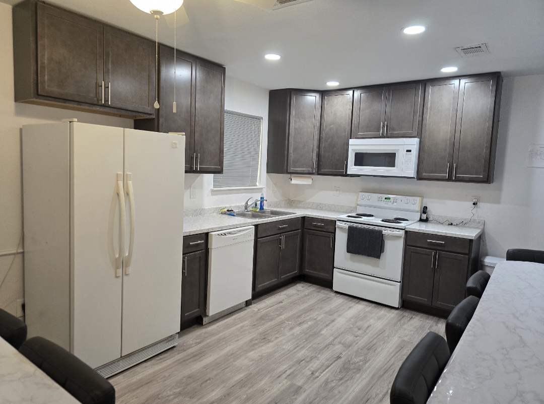 Bright remodeled kitchen with warm natural light, simple cabinets, and tidy counters.